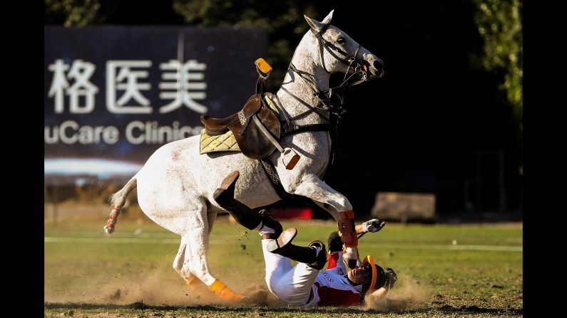 Wang Gang of Team AXUS falls during a polo match at Beijing Tang Polo Club on September 23 in Beijing.