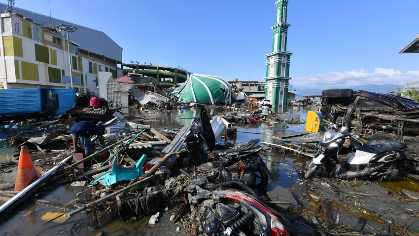 A resident sifts through debris past the rubble of a mosque in Palu, Indonesia's Central Sulawesi following the September 28 earthquake and tsunami.