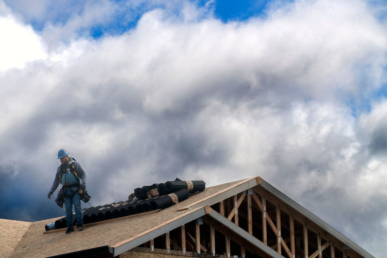 A construction worker walks down the roof of a single family home in Stockton, California, on March 15. 