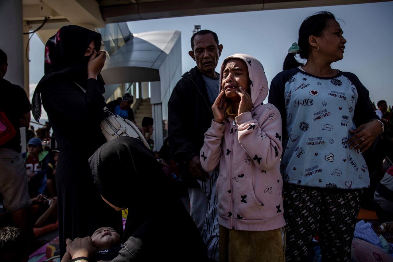 A young girl cries outside the Palu airport after it reopened on October 1. Hundreds rushed to the airport hoping to catch one of the few flights out of the area.