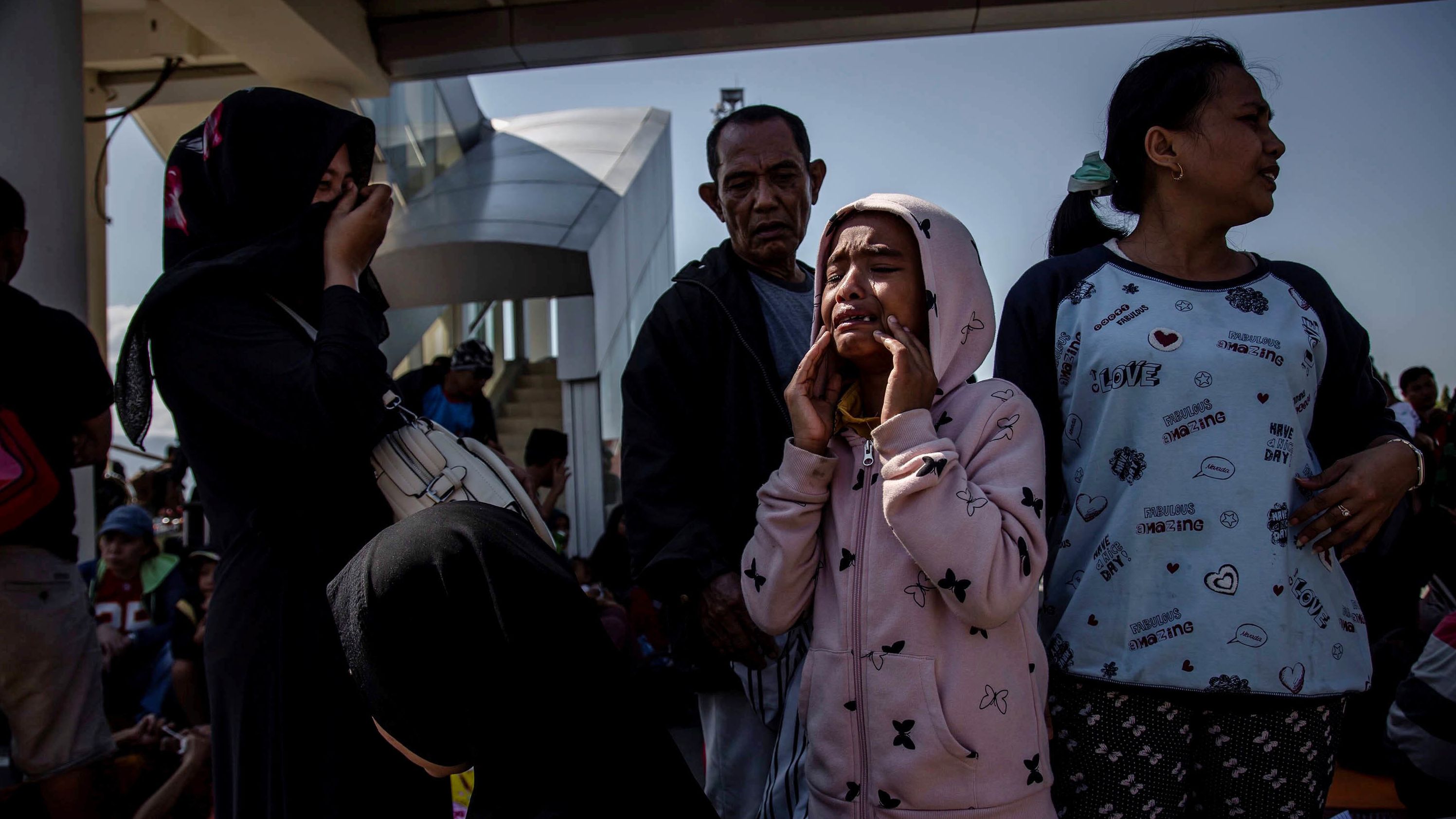 A young girl cries outside the Palu airport after it reopened on October 1. Hundreds rushed to the airport hoping to catch one of the few flights out of the area.