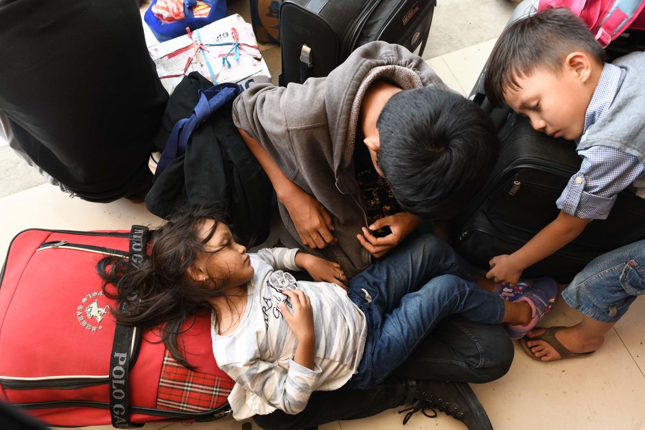 Survivors rest outside the airport as they wait for a flight out of Palu on October 1.