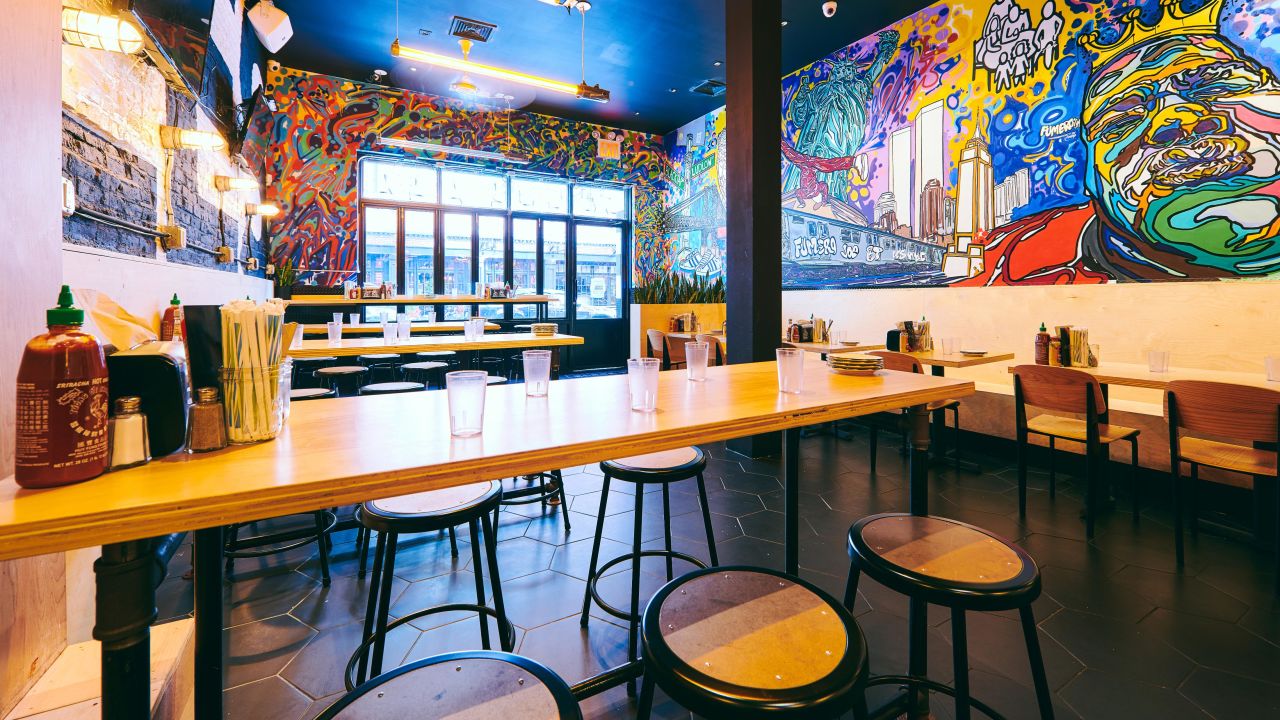 Black Tap's location on the Lower East Side features neon signs and street art.