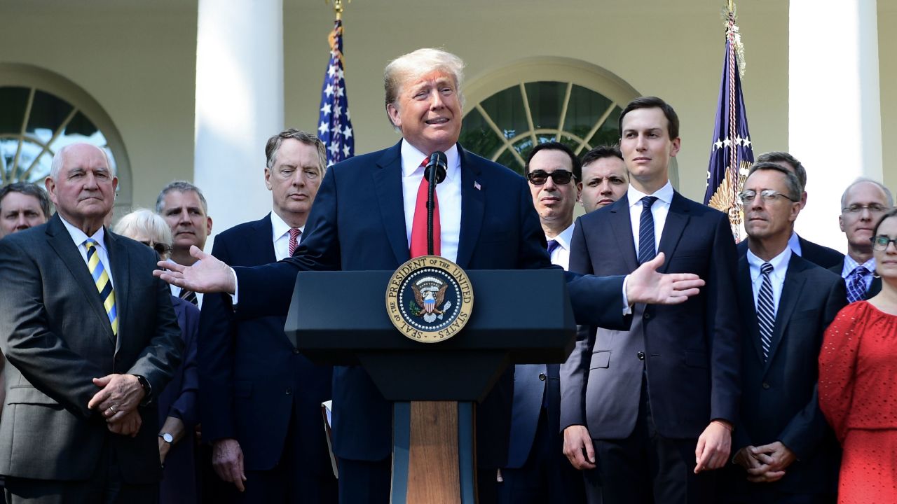 US President Donald Trump surrounded by staff speaks from the Rose Garden of the White House in Washington, DC, remarking on the United StatesMexicoCanada Agreement on October 1, 2018. (Photo by Jim WATSON / AFP)        (Photo credit should read JIM WATSON/AFP/Getty Images)