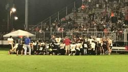 Football players and coaches from Pike County and Peach County high schools knelt in prayer after Dylan Thomas was taken to the hospital on September 28, 2018.
