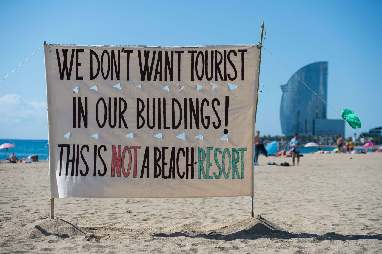An anti-tourism banner on La Barceloneta beach, illustrating how tensions are rising in Barcelona.