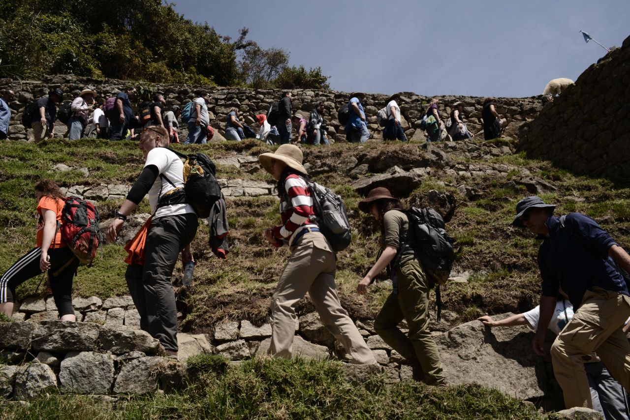 In Machu Picchu, in Peru, crowds of people line up to explore the Inca ruins.