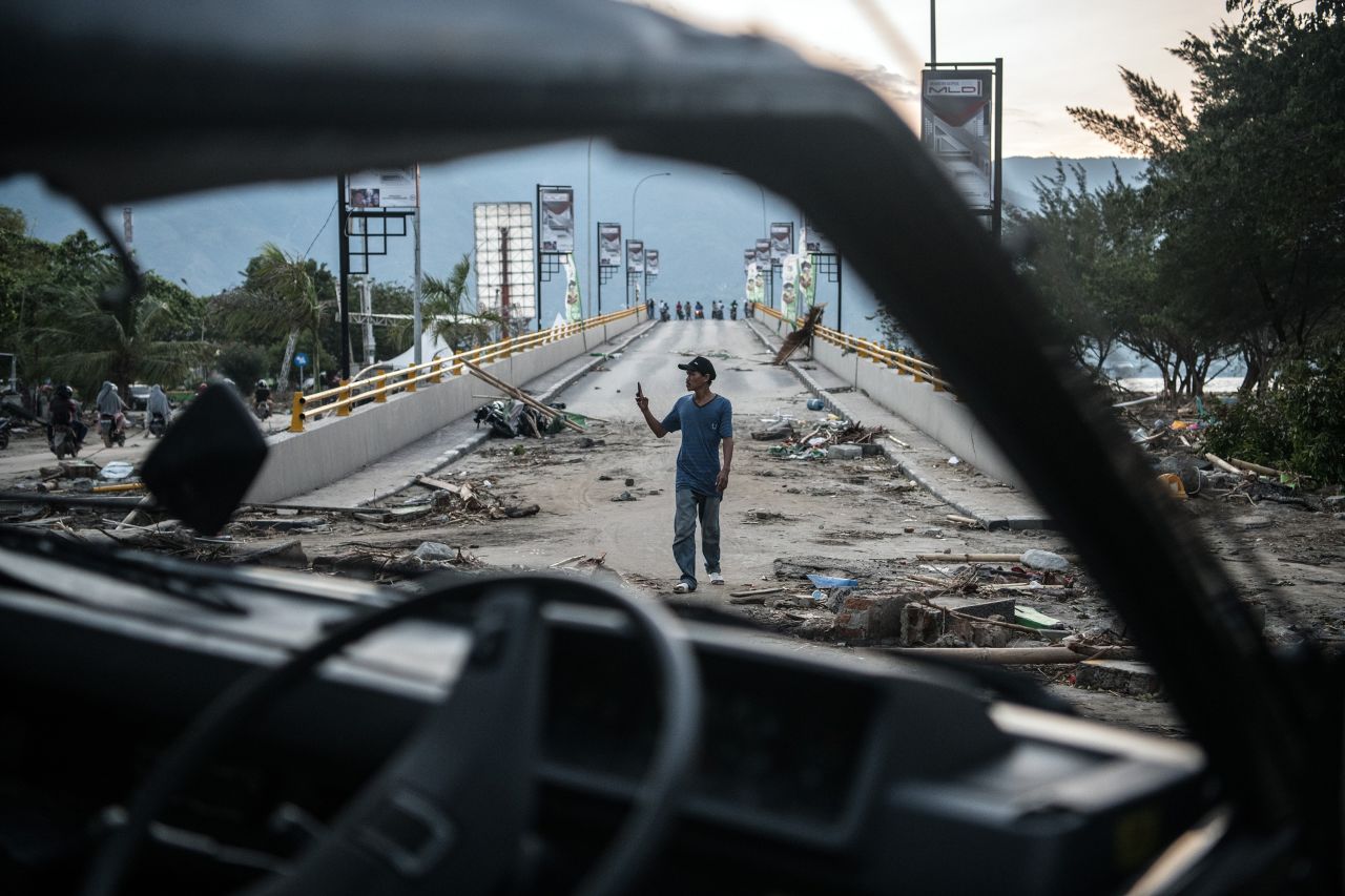 A man takes a photo on a damaged bridge in Palu on October 1.