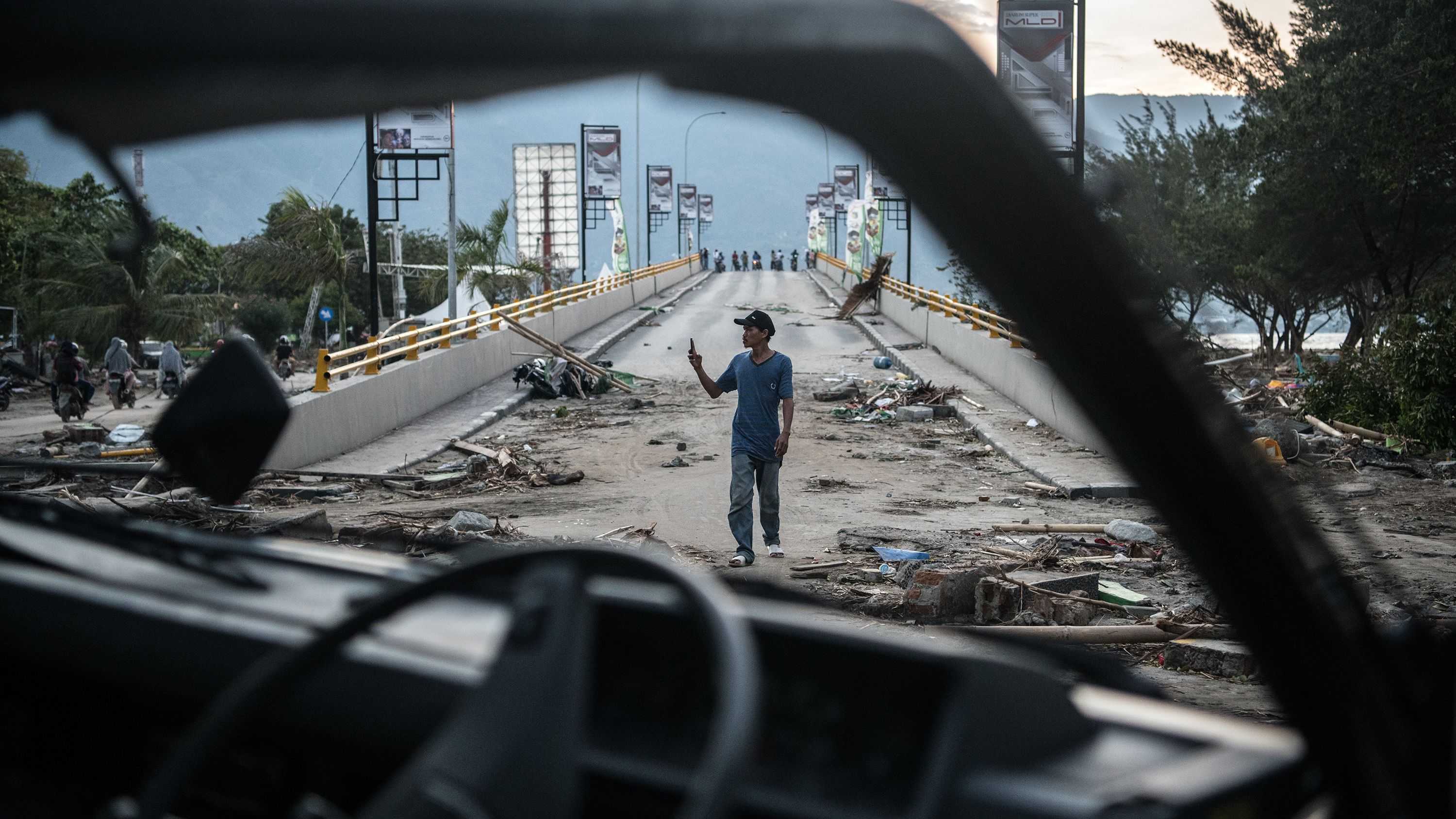 A man takes a photo on a damaged bridge in Palu on October 1.