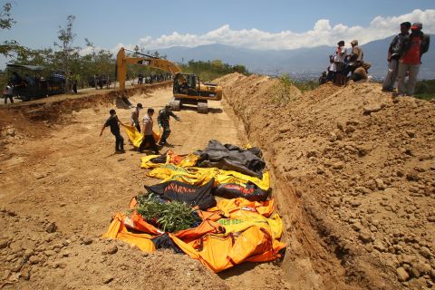 Bodies are carried to a mass grave in Palu's Balaroa village on October 1.