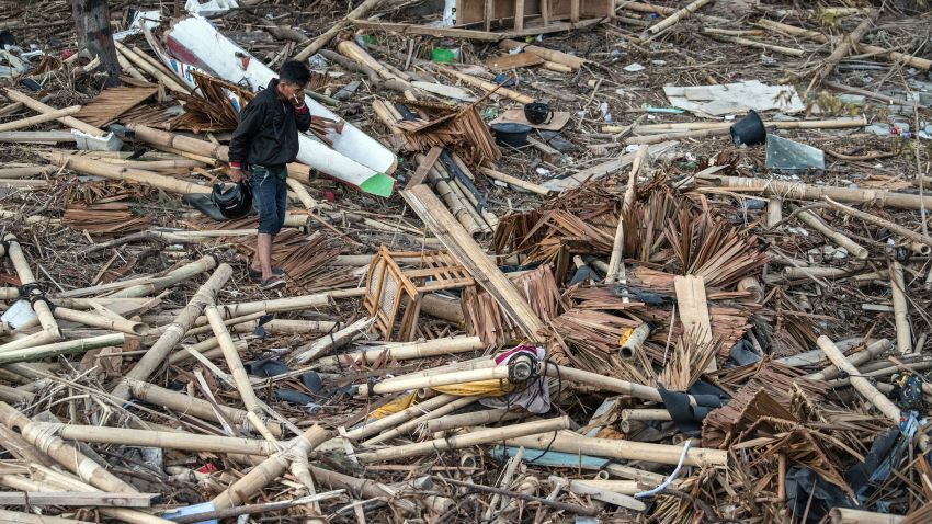 PALU, INDONESIA - OCTOBER 01: A man covers his nose as he walks through the rubble and debris of a building that was destroyed by a tsunami, on October 01, 2018 in Palu, Indonesia. Over 844 people have been confirmed dead after a tsunami triggered by a magnitude 7.5 earthquake slammed into Indonesia's coastline on the island of Sulawesi, causing thousands of homes to collapse, along with hospitals, hotels and shopping centers. Emergency services fear that the death toll could rise into the thousands as rescue teams made contact with the nearby cities of Donggala and Mamuju and strong aftershocks continue to rock the city. (Photo by Carl Court/Getty Images)