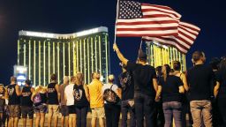 People form a human chain around the shuttered site of a country music festival where a gunman opened fire on the first anniversary of the mass shooting, Monday, Oct. 1, 2018, in Las Vegas. As people were linking arms and holding hands Monday night near the concert site, officials and several hundred others across town listened to bagpipes and the names of the 58 victims being read aloud. (AP Photo/John Locher)