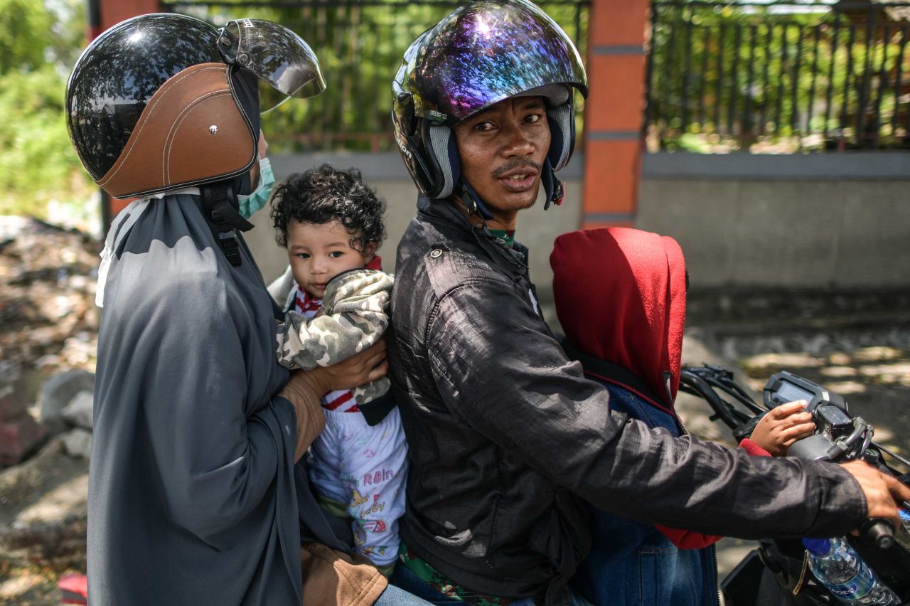 A family on a motorcycle waits to learn the status of relatives on October 2.