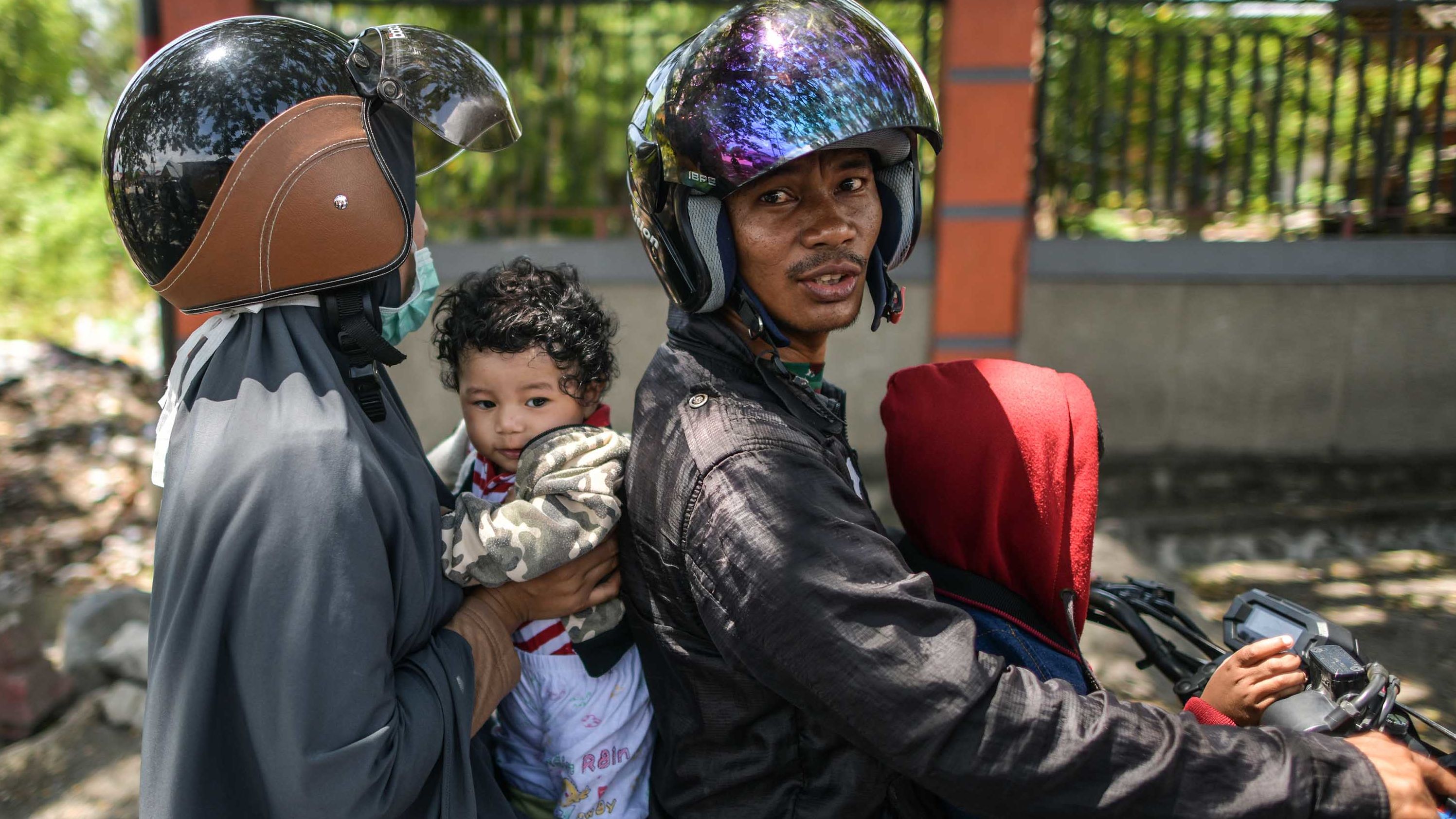 A family on a motorcycle waits to learn the status of relatives on October 2.
