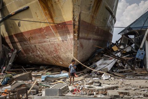 A boy stands in front of a stranded ship in Donggala on October 2.