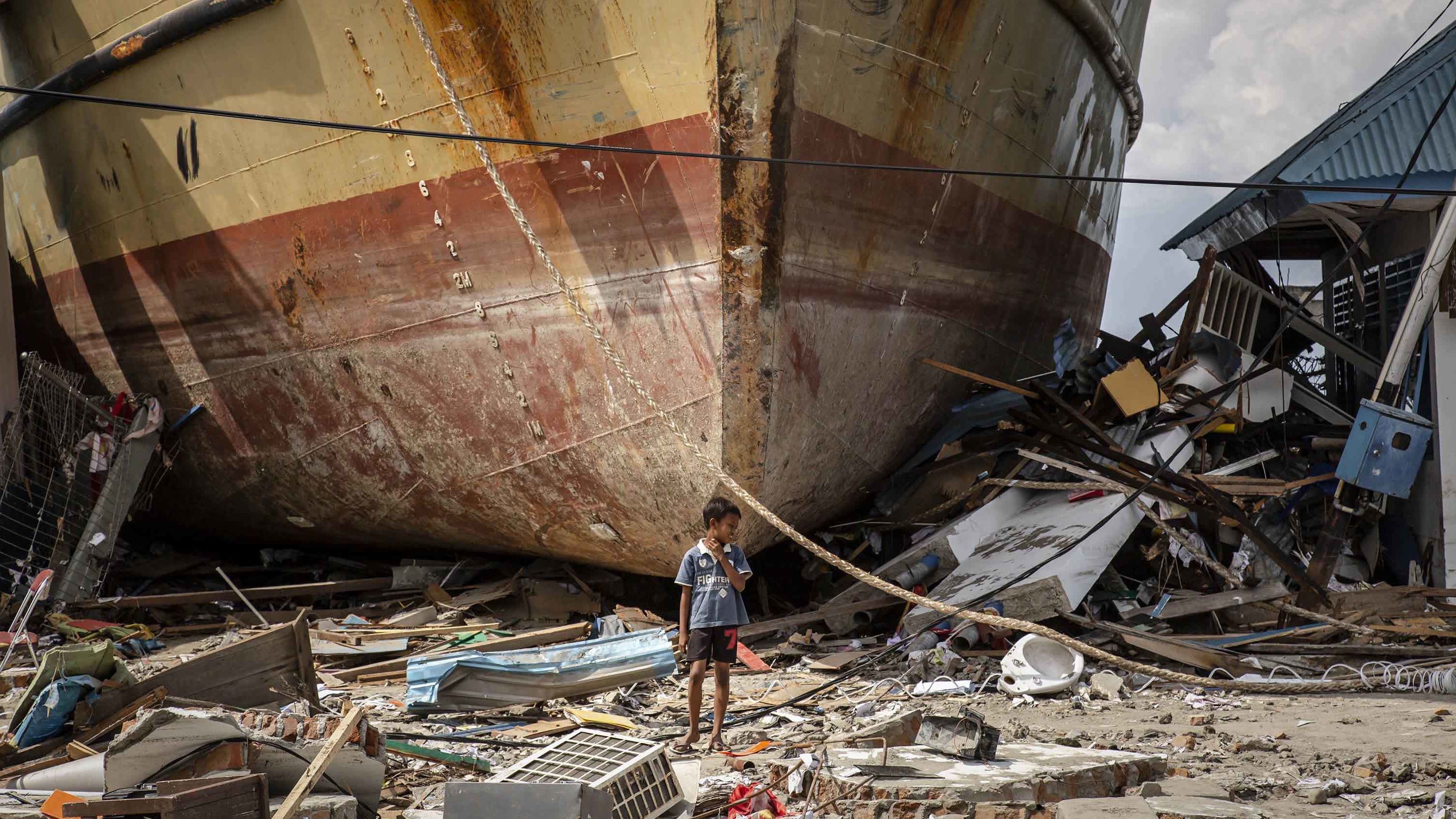 A boy stands in front of a stranded ship in Donggala on October 2.