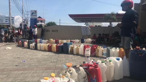 Bottles line up outside a petrol station in the city of Palu, waiting to be filled with precious fuel.