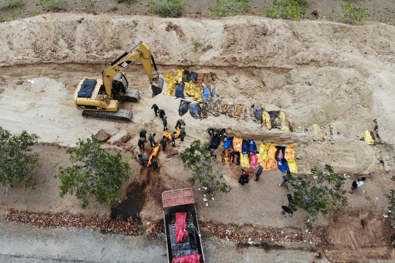 Indonesian soldiers bury earthquake victims in a mass grave in Poboya on October 2.