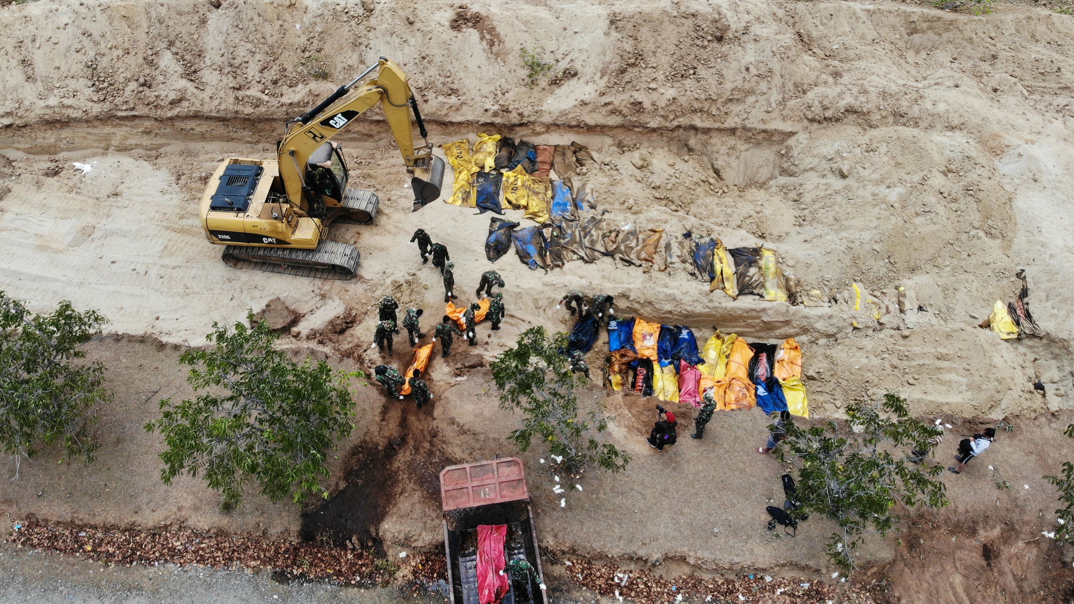 Indonesian soldiers bury earthquake victims in a mass grave in Poboya on October 2.