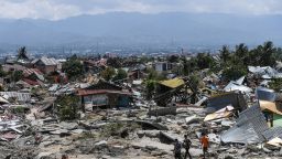 Residents walk amid debris in Perumnas Balaroa village in Palu, Indonesia's Central Sulawesi on October 2, 2018, after an earthquake and tsunami hit the area on September 28. - The bodies of dozens of students have been pulled from their landslide-swamped church in Sulawesi, officials said on October 2, as an international effort to help nearly 200,000 Indonesia quake-tsunami victims ground into gear. (Photo by Mohd RASFAN / AFP)        (Photo credit should read MOHD RASFAN/AFP/Getty Images)