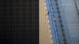 TOPSHOT - In this photograph taken on August 23, 2016, two men take a series of selfies as they sit on the ledge of a high-rise building in an activity called "rooftopping" in Hong Kong. / AFP PHOTO / Romeo GACAD / The erroneous mention[s] appearing in the metadata of this photo by ROMEO GACAD has been modified in AFP systems in the following manner: corrects byline spelling to [ROMEO GACAD] instead of [ROMMEO GACAD]. Please immediately remove the erroneous mention[s] from all your online services and delete it (them) from your servers. If you have been authorized by AFP to distribute it (them) to third parties, please ensure that the same actions are carried out by them. Failure to promptly comply with these instructions will entail liability on your part for any continued or post notification usage. Therefore we thank you very much for all your attention and prompt action. We are sorry for the inconvenience this notification may cause and remain at your disposal for any further information you may require.        (Photo credit should read ROMEO GACAD/AFP/Getty Images)