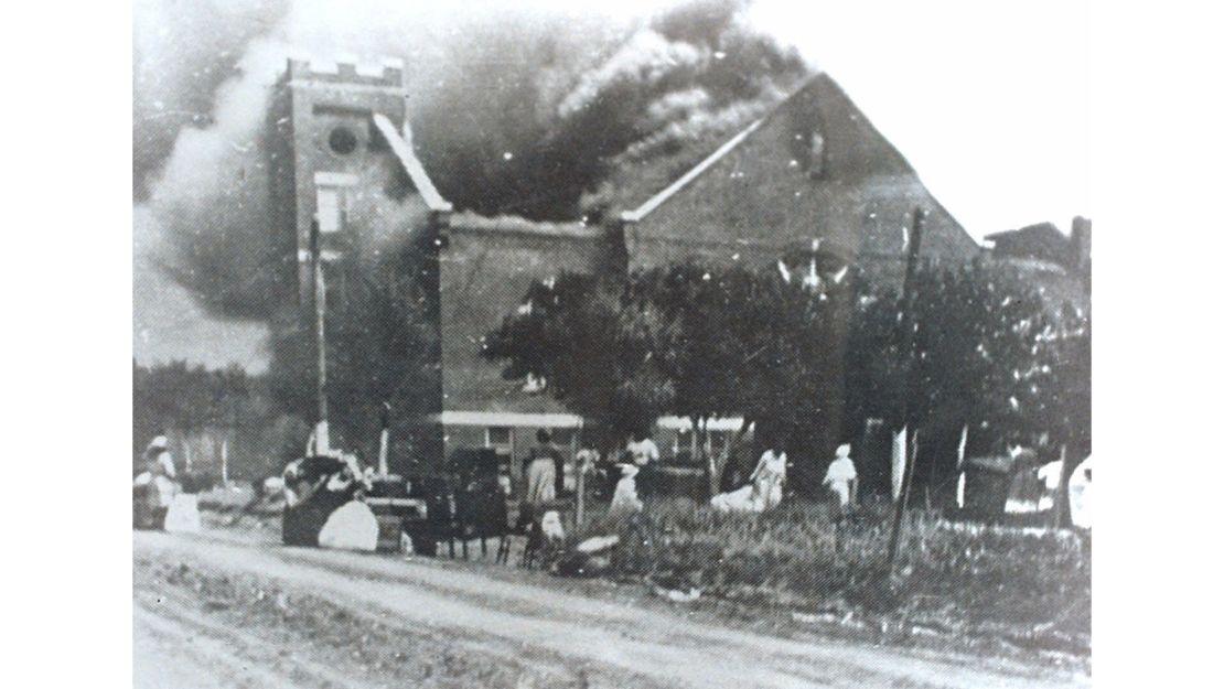 Smoke rolls out of Mount Zion Baptist Church after white mobs torched the building. 