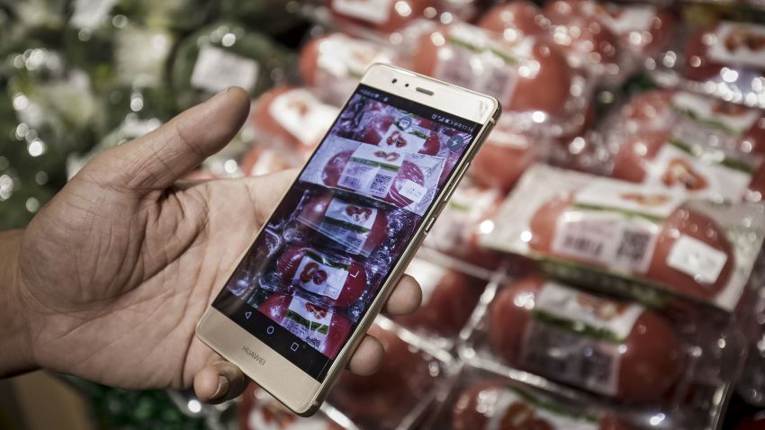 A customer displays the Hema application on a Huawei Technologies Co. smartphone while shopping at an Alibaba Group Holding Ltd. Hema Store in Shanghai, China, on Tuesday, Sept. 12, 2017. Hema stores are one-stop shops where users can pay with their mobile app, get recommendations by scanning product bar codes, and have seafood cooked on the spot, and also serving as last-mile delivery fulfillment centers, where goods get to buyers within 30 minutes. Photographer: Qilai Shen/Bloomberg via Getty Images