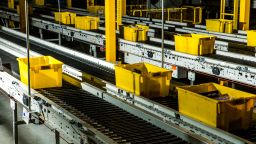 Yellow crates zip through the warehouse on a conveyor belt.