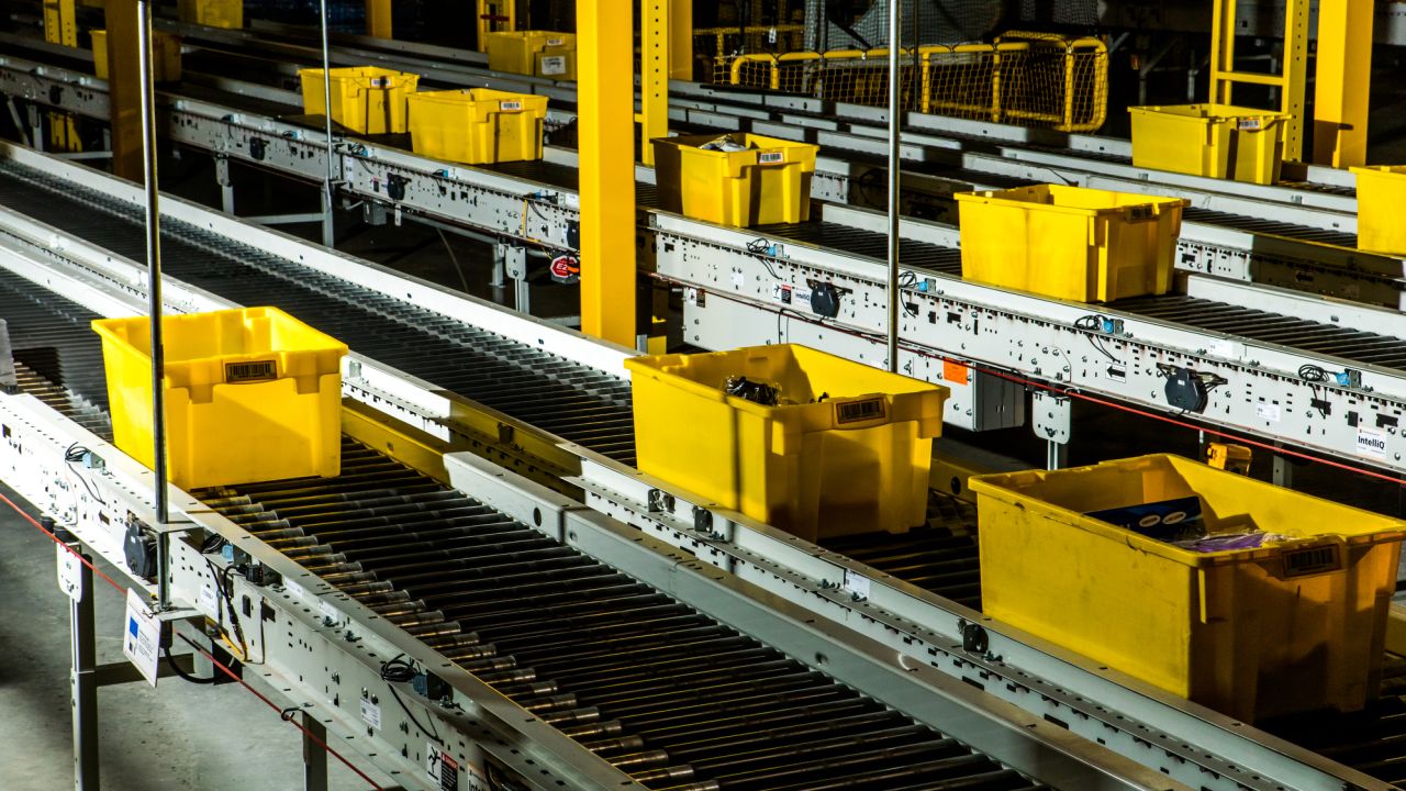Crates zip through the fulfillment center on a conveyor belt.