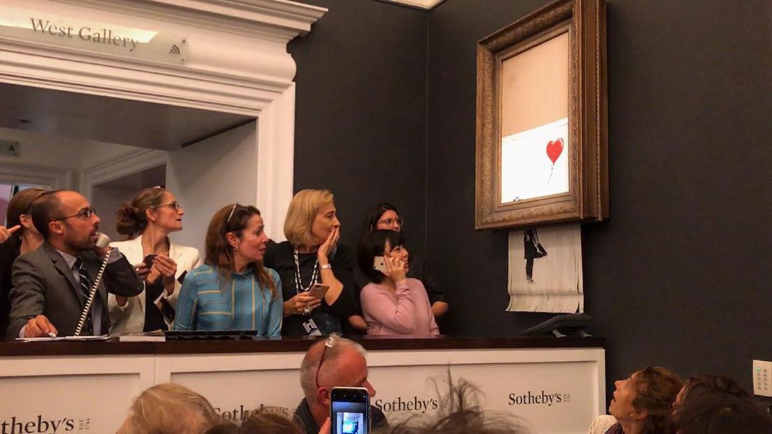 Onlookers at a Sotheby's auction react as Banksy's artwork is shredded in 2018.