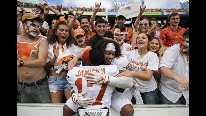 Texas Longhorns defensive back D'Shawn Jamison and defensive back P.J. Locke III celebrate with fans after their game against the Oklahoma Sooners at the Cotton Bowl on October 6, 2018. The Lornghorns won the Red River Showdown by a score of 48-45.