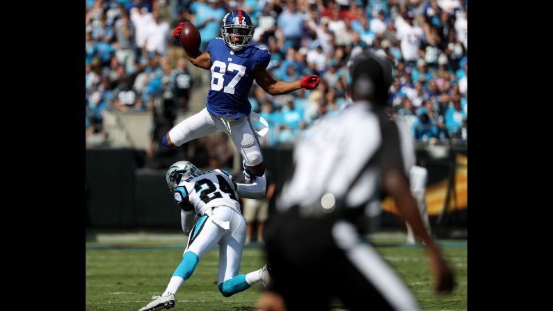 Sterling Shepard of the New York Giants jumps over James Bradberry of the Carolina Panthers in the second quarter during their game at Bank of America Stadium on October 7, 2018 in Charlotte, North Carolina.