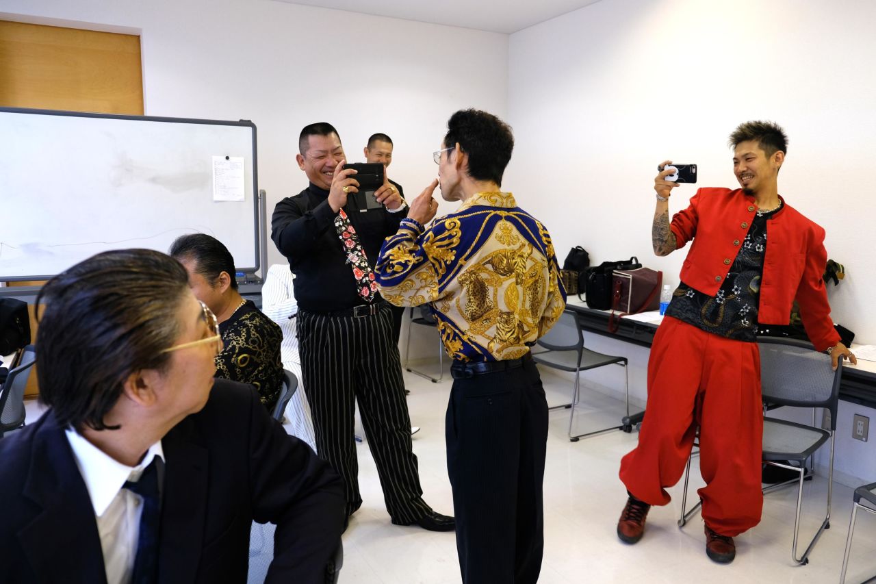 Takakura-gumi's ex-mobsters joke with one another in their makeshift dressing room.