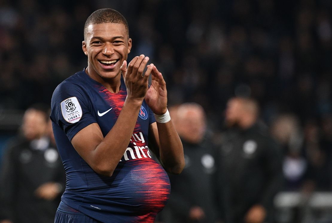 Mbappe hides the match's ball under his jersey after scoring four goals against Lyon.