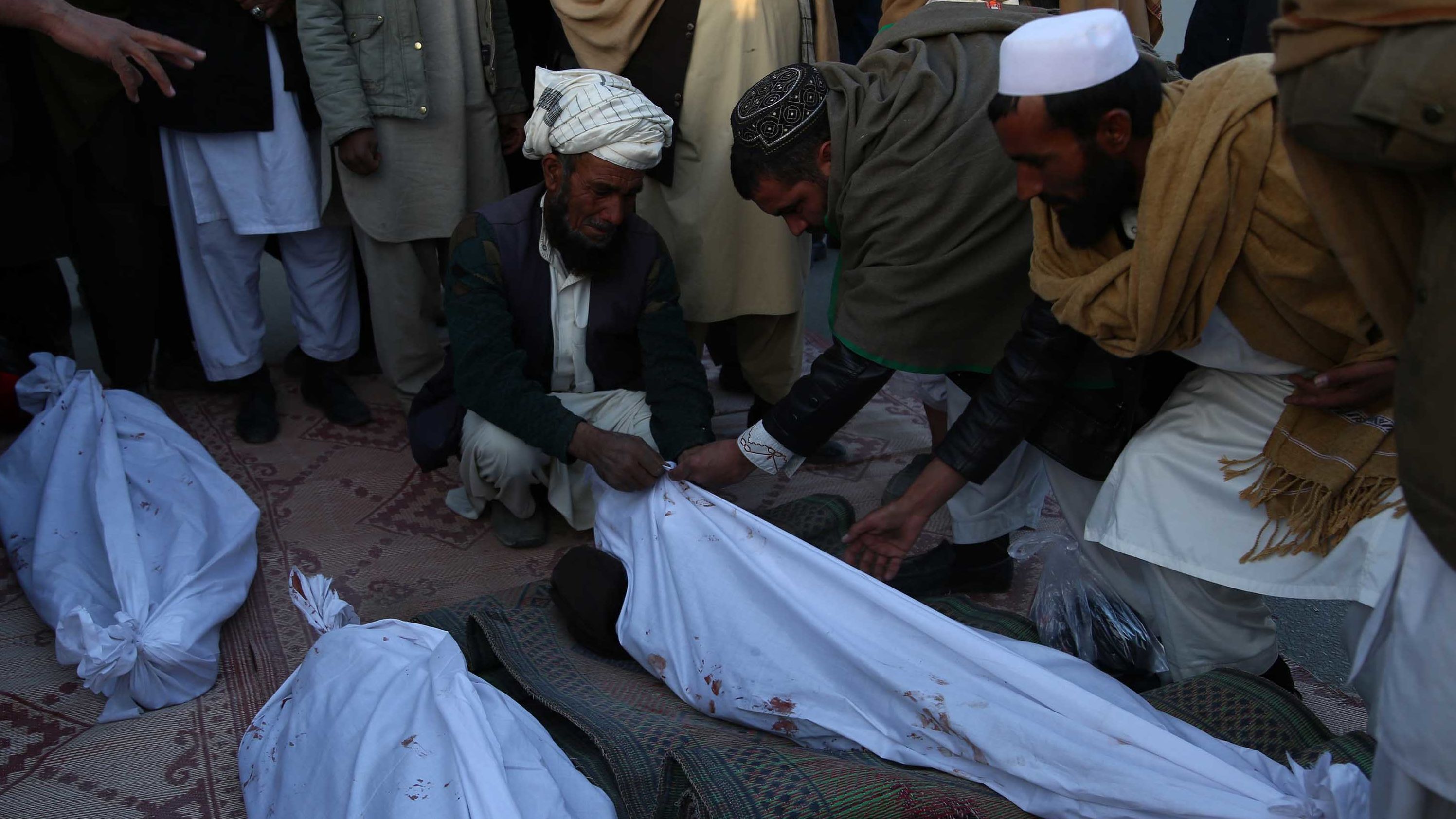 Afghans mourn after four children were killed in an airstrike in Ghazni Province on February 7.