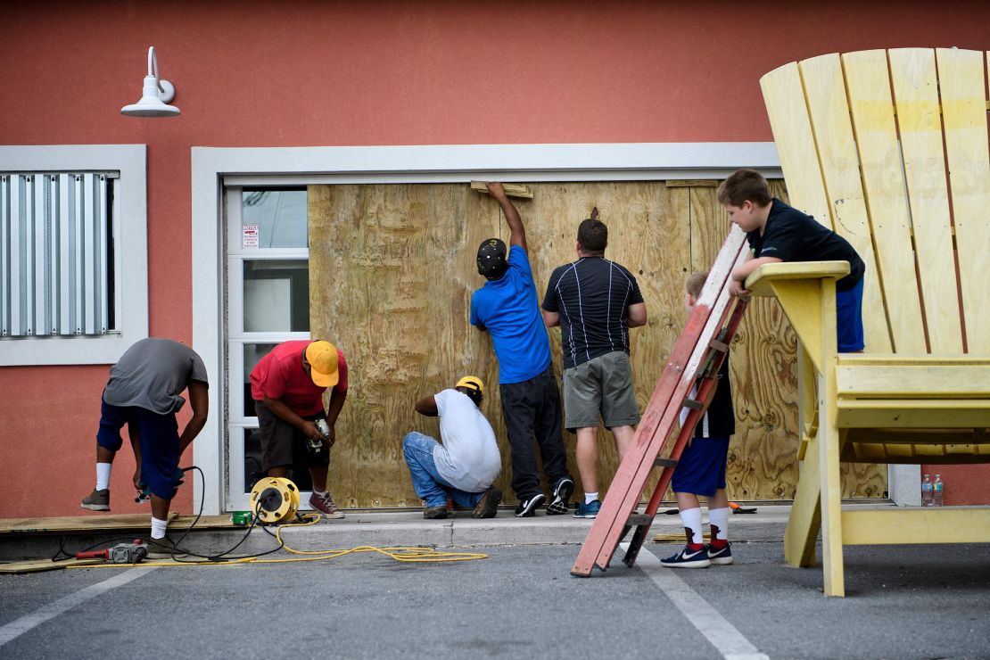 Workers board up the windows of Marco's Pizza as Hurricane Michael approached on Tuesday in Panama City Beach, Florida.