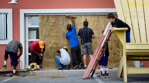Workers board up the windows of Marco's Pizza as Hurricane Michael approached on Tuesday in Panama City Beach, Florida.