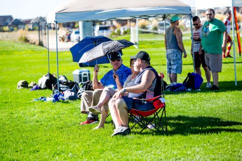 Fans shade themselves with umbrellas to guard against the 100 degrees Fahrenheit heat in Denver. 