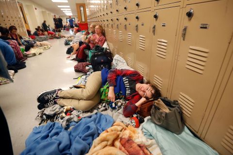 Emily Hindle lies on the floor at an evacuation shelter set up at a Panama City Beach high school on October 10.