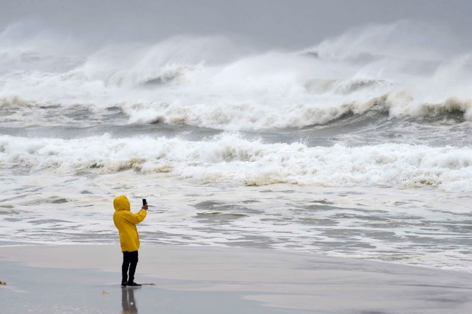 A person takes pictures of the surf and fishing pier on Okaloosa Island in Fort Walton Beach, Florida.