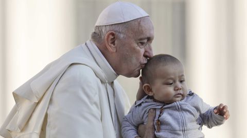 Pope Francis kisses a child as he arrives in St. Peter's Square to hold his weekly general audience on Wednesday.