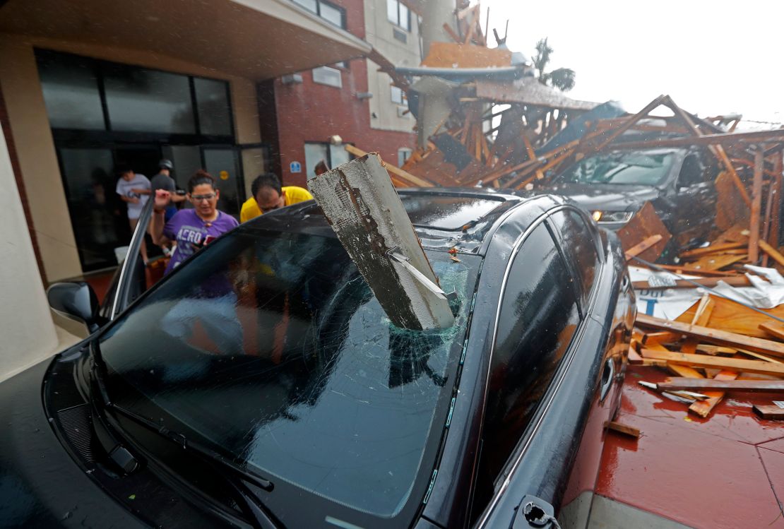 A woman checks on her vehicle after Hurricane Michael destroyed a hotel canop  in Panama City Beach, Florida. 