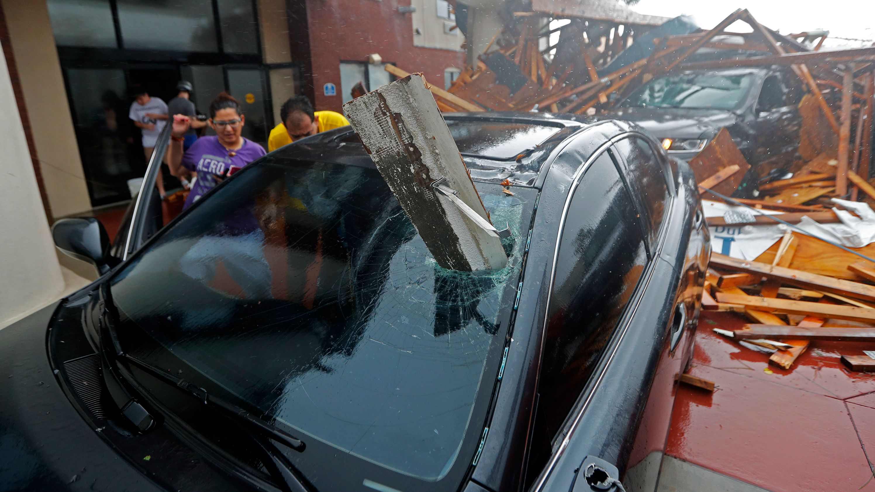 A woman checks on her vehicle after a hotel canopy collapsed in Panama City Beach.