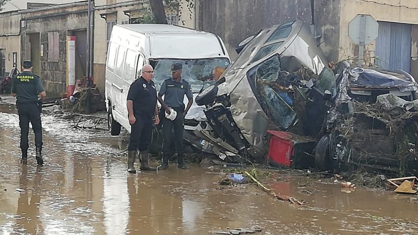 Police officers stand next to vehicles destroyed in Sant Llorenc, the town hardest hit by the downpours located 60 kilometers (40 miles) east of Mallorca's capital, Palma, Spain, on Wednesday, Oct. 10, 2018. At least five people died and five more remained missing on Wednesday after torrential rainstorms caused flash flooding in Spain's Mallorca island, authorities said. (AP Photo/Juan Pedro Martinez)