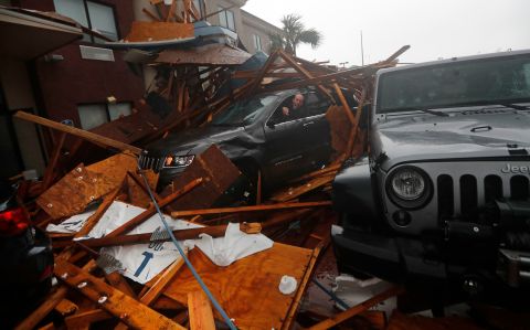 A storm chaser climbs into his vehicle to retrieve equipment after a hotel canopy collapsed in Panama City Beach on October 10.