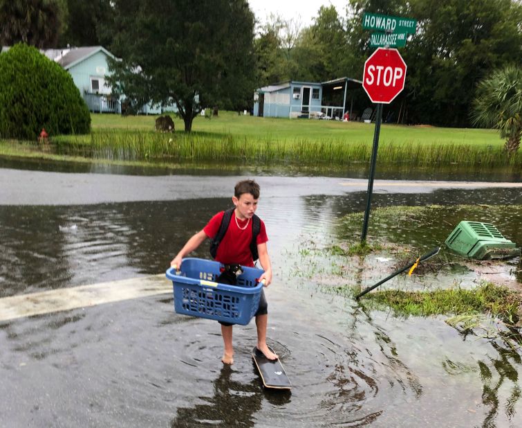 Jayden Morgan, 11, evacuates his home as water starts to flood his neighborhood in St. Marks.