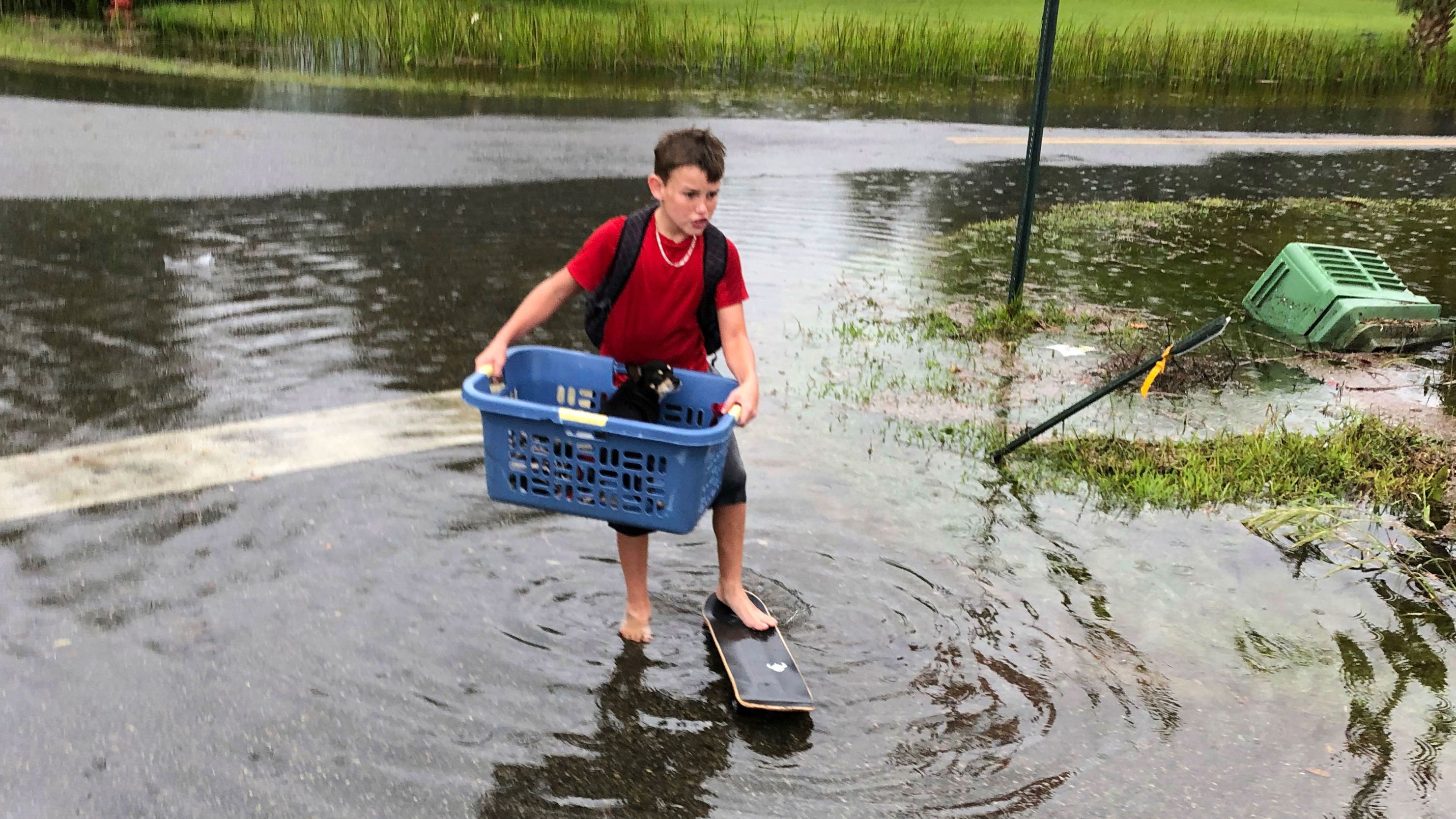 Jayden Morgan, 11, evacuates his home as water starts to flood his neighborhood in St. Marks.