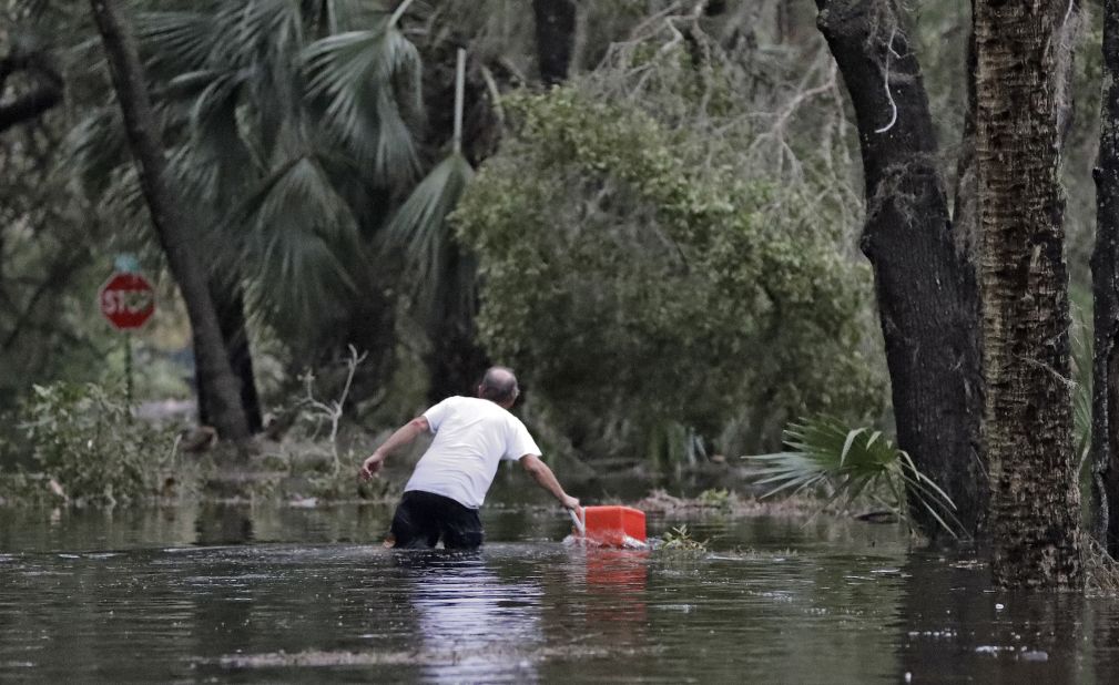 A resident of St. Marks, Florida, pulls a cooler out of the floodwaters near his home.
