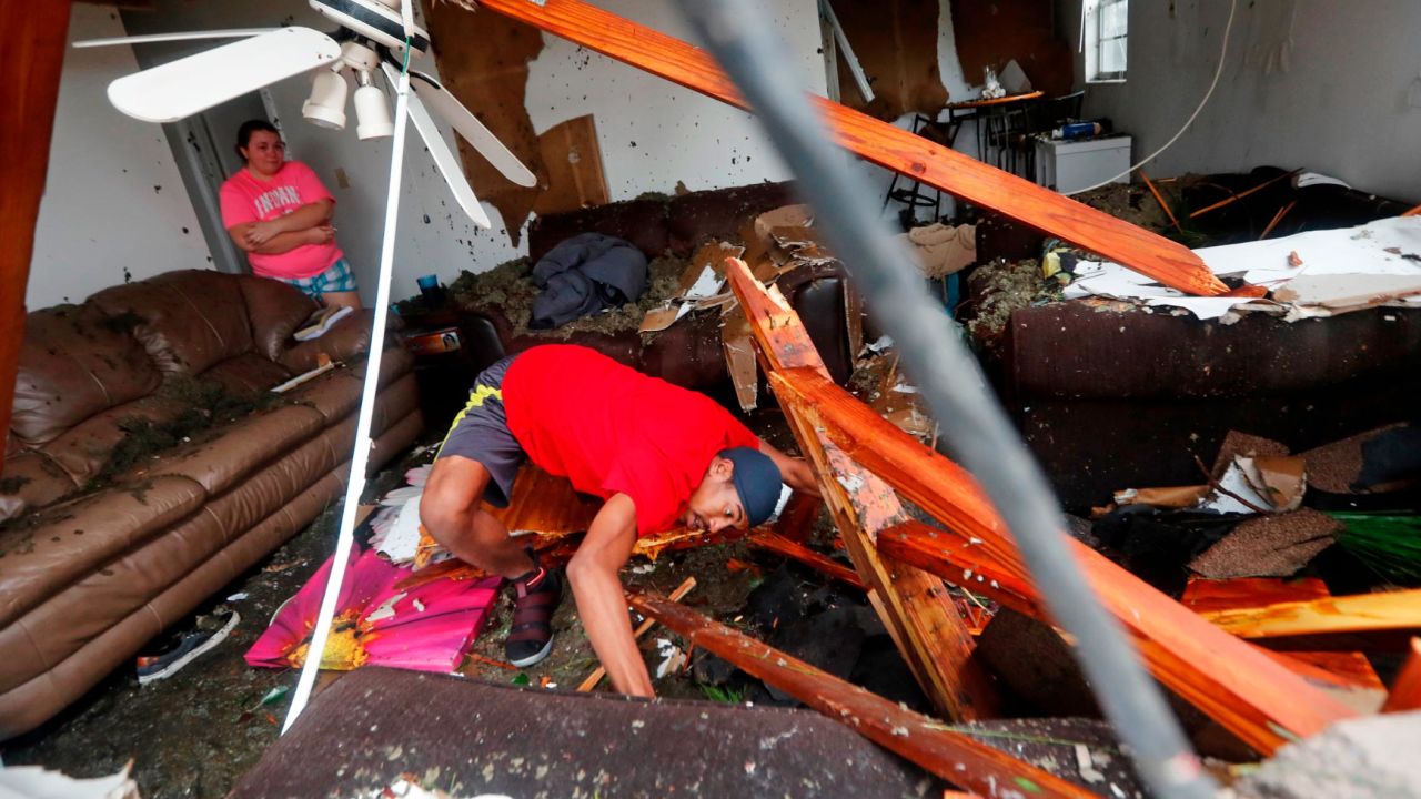 Dorian Carter searches for his missing cat after several trees fell on his Panama City home Wednesday.