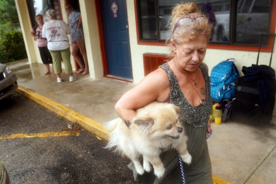 Lenora Adams evacuates a motel with her dog as the hurricane comes ashore in Panacea, Florida, on October 10.